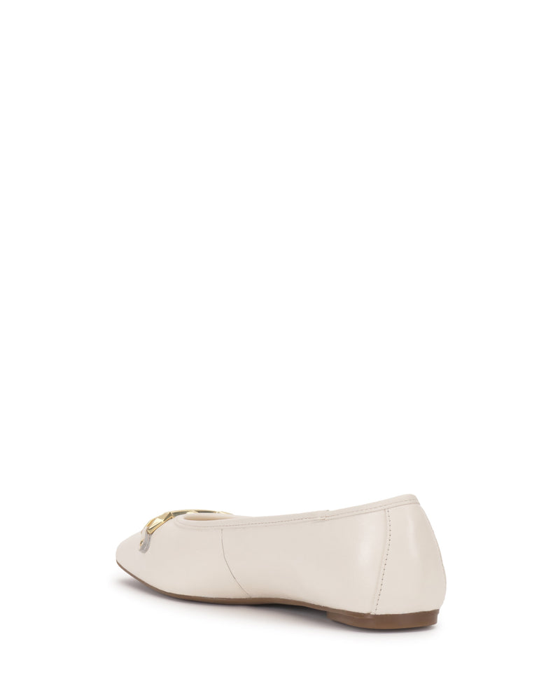 The Vince Camuto Virna Link Ballet Flat in beige features a slightly pointed toe, flat brown sole, and polished gold buckle hardware. Shown from the back on a white background, it's perfect for versatile style.