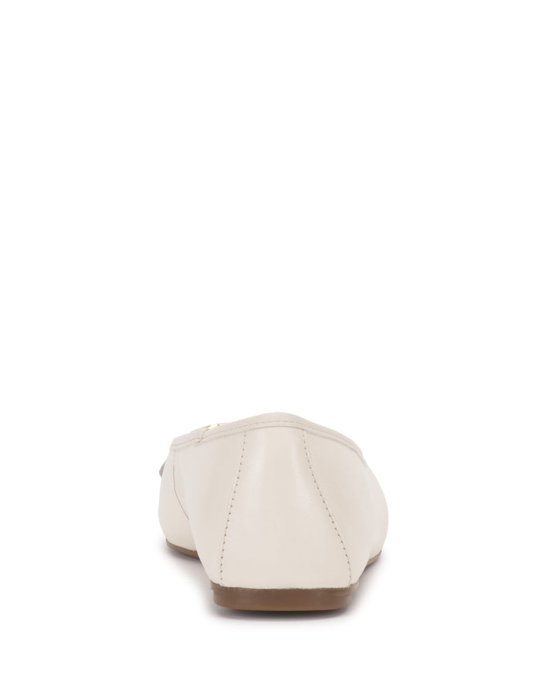 The Vince Camuto Virna Link Ballet Flat is shown from the back in cream, featuring visible stitching, polished hardware, and a light brown sole—all set against a white background for versatile style.