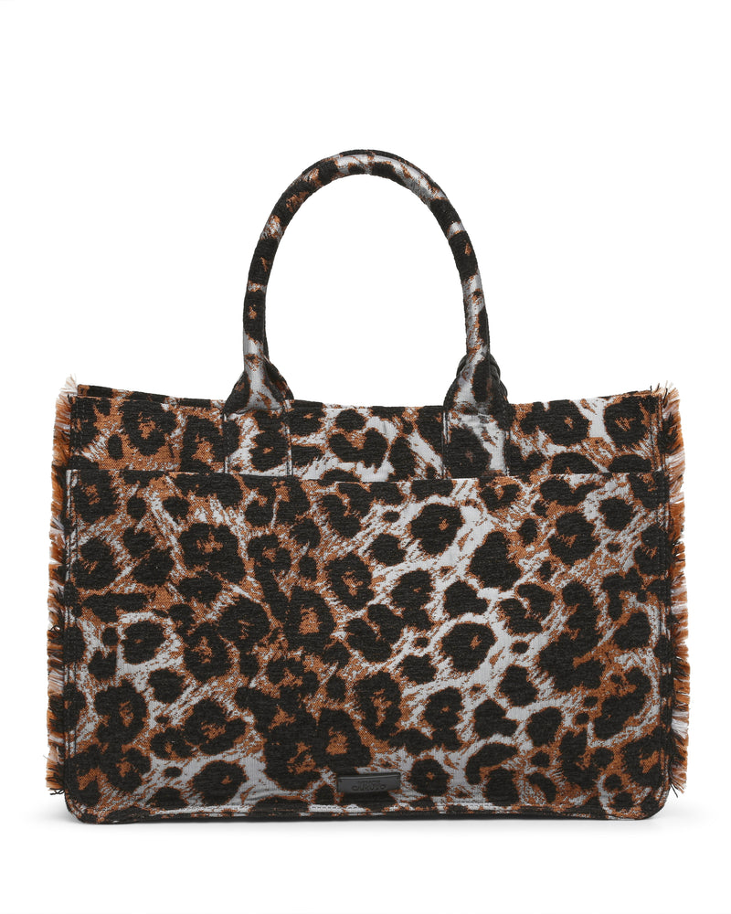 A rectangular Zhury Tote Bag by Vince Camuto, designed with two handles and adorned with a striking brown and black leopard print, features a textured, slightly furry surface and visible fringe along the edges.