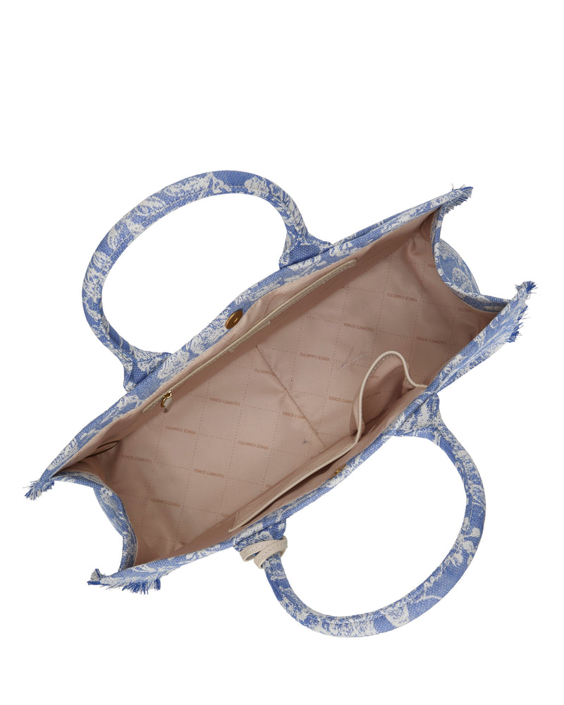 Open the Vince Camuto Zhury Tote Bag in a blue and white pattern with two handles, featuring a spacious beige quilted lined interior, one small zippered pocket, and one open pocket inside.