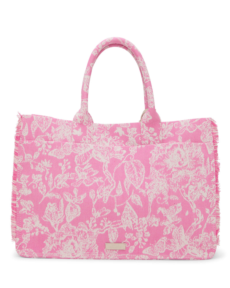 The Vince Camuto Zhury Tote Bag showcases a pink and white floral design, two handles, fringed edges, and a small metallic rectangular logo on the front.
