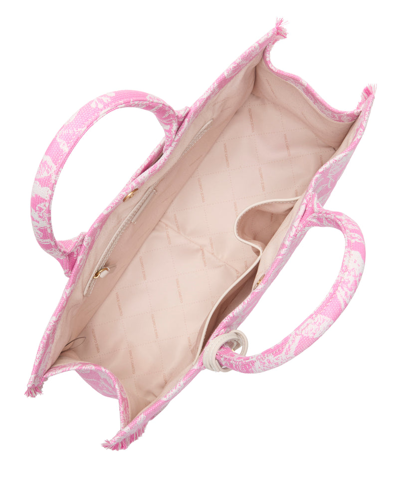 Top view of the Vince Camuto Zhury Tote Bag with dual handles, a pink and white patterned exterior, beige quilted interior, one zippered pocket, and one open pocket.