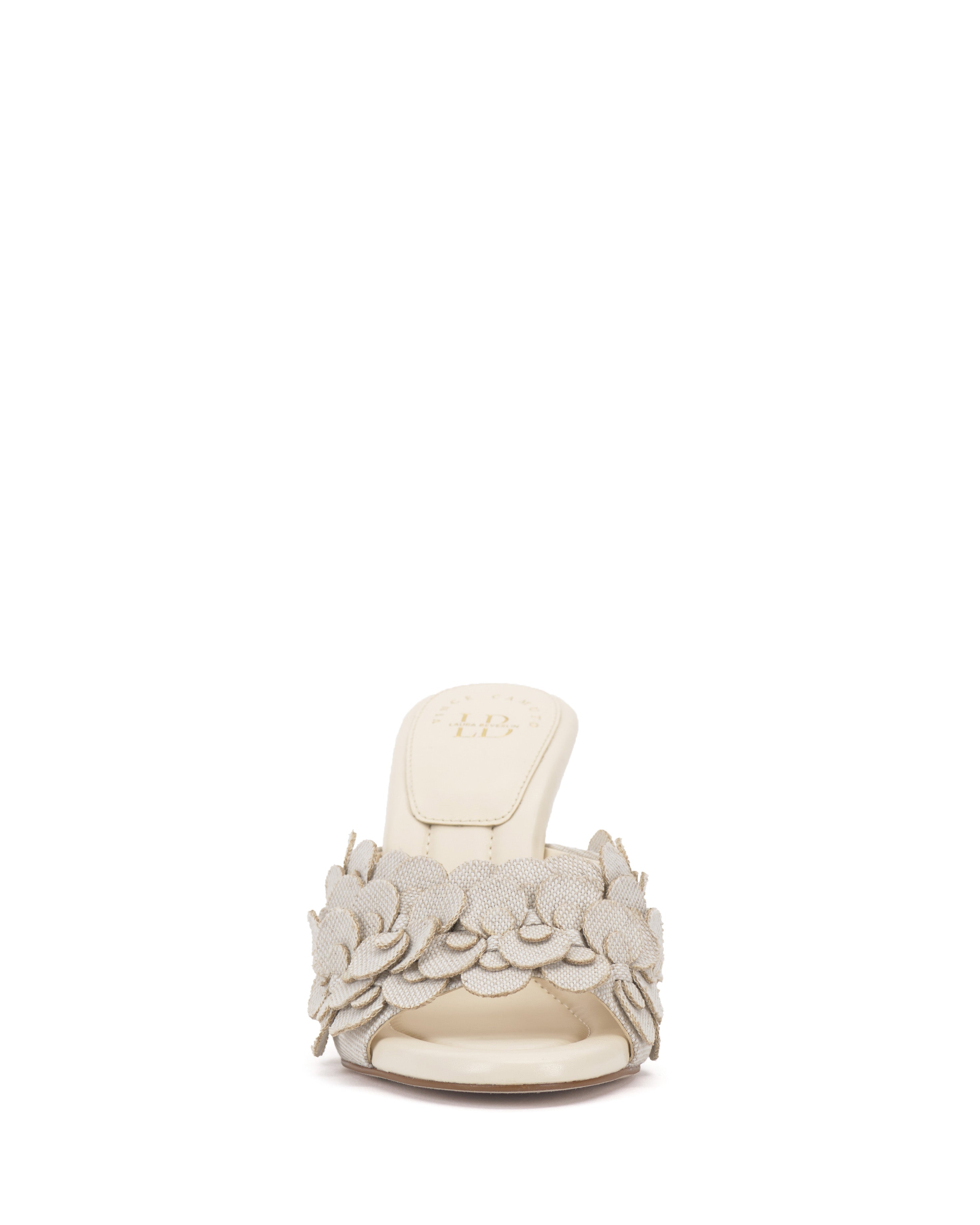 Front view of the Vince Camuto Rose Mule, a cream 3D blossom mule with open toe, low heel, padded footbed, and decorative fabric flowers on the wide strap across the foot.