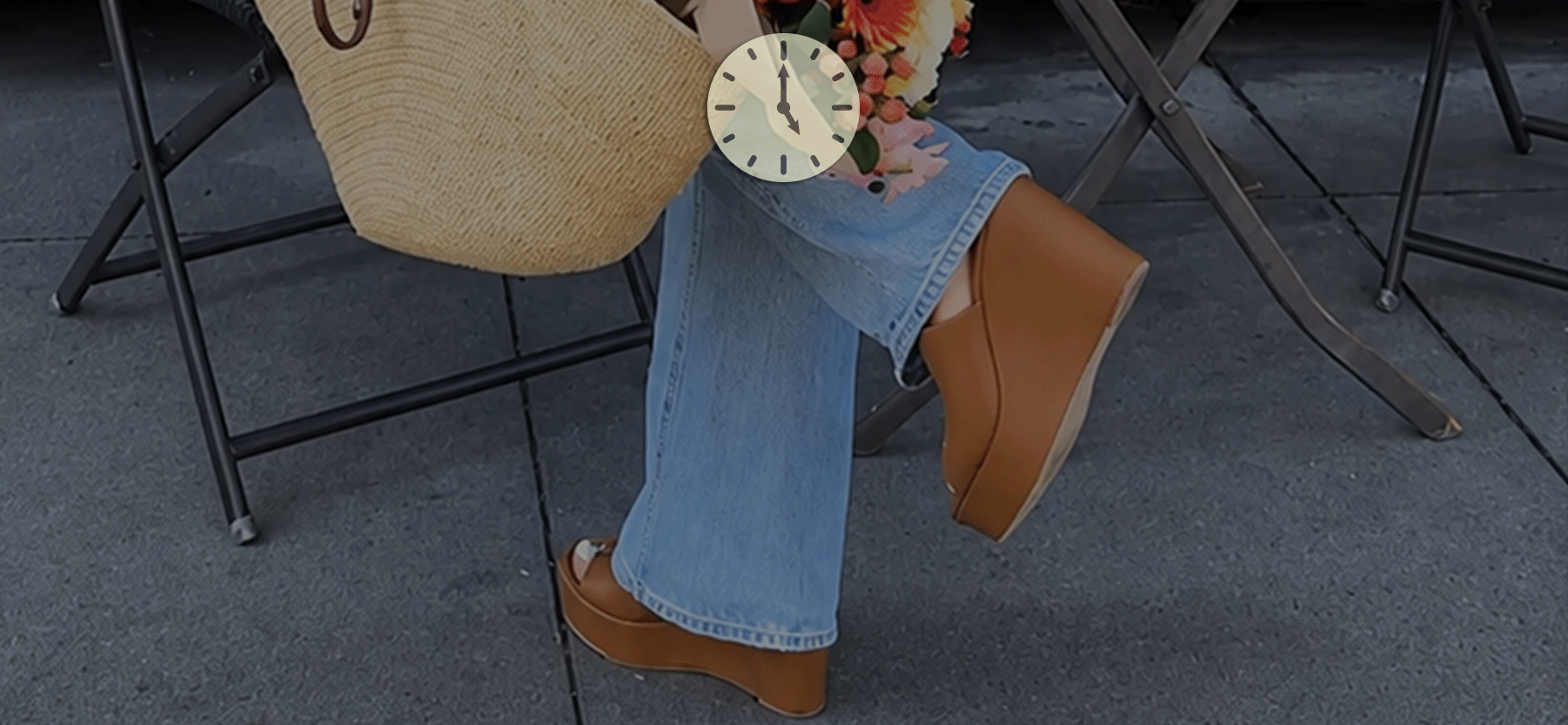 woman in wedge sandals holding a tan bag with flowers