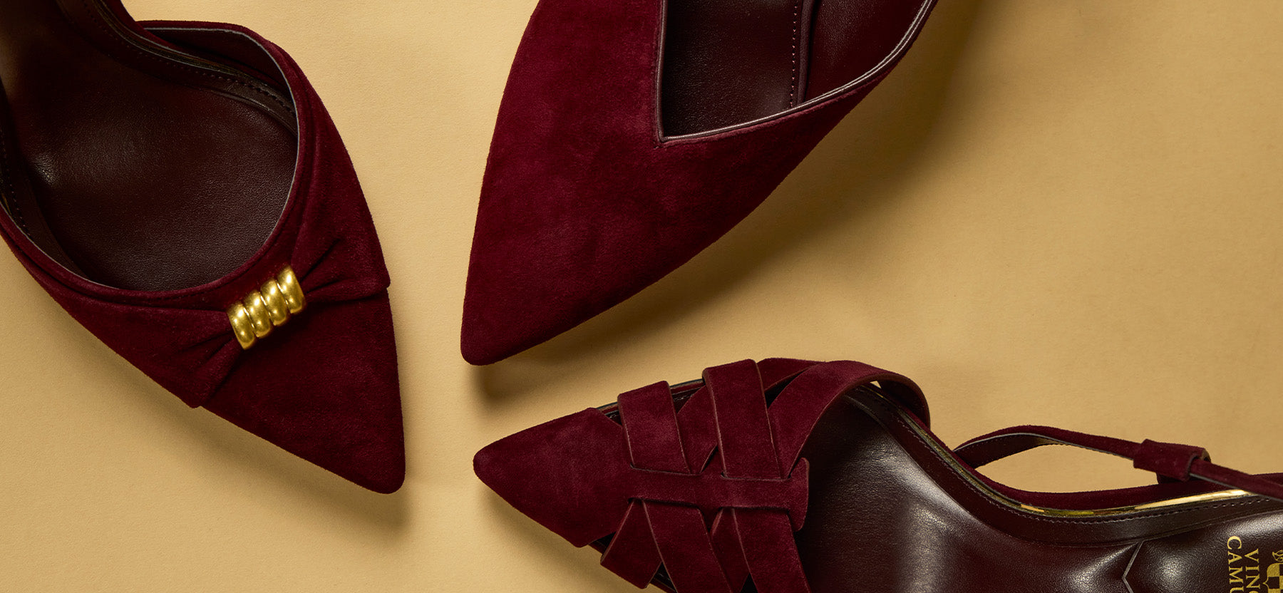 Three burgundy suede pointed-toe heels arranged on a warm beige background, showing the inner side with a gold buckle detail, the outer side, and a slingback version with woven straps.
