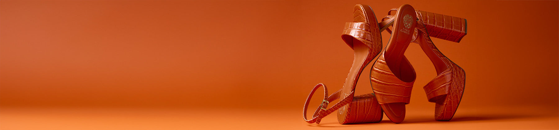 three orange textured heels on an orange background 