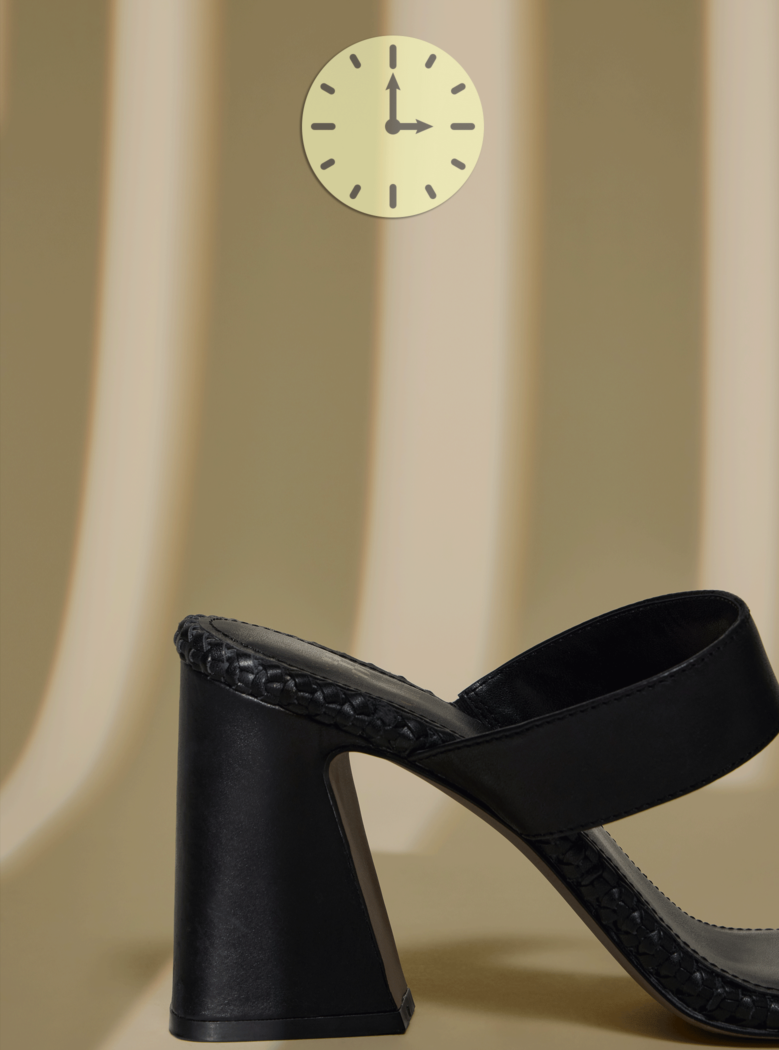 black high heeled shoes on tan background