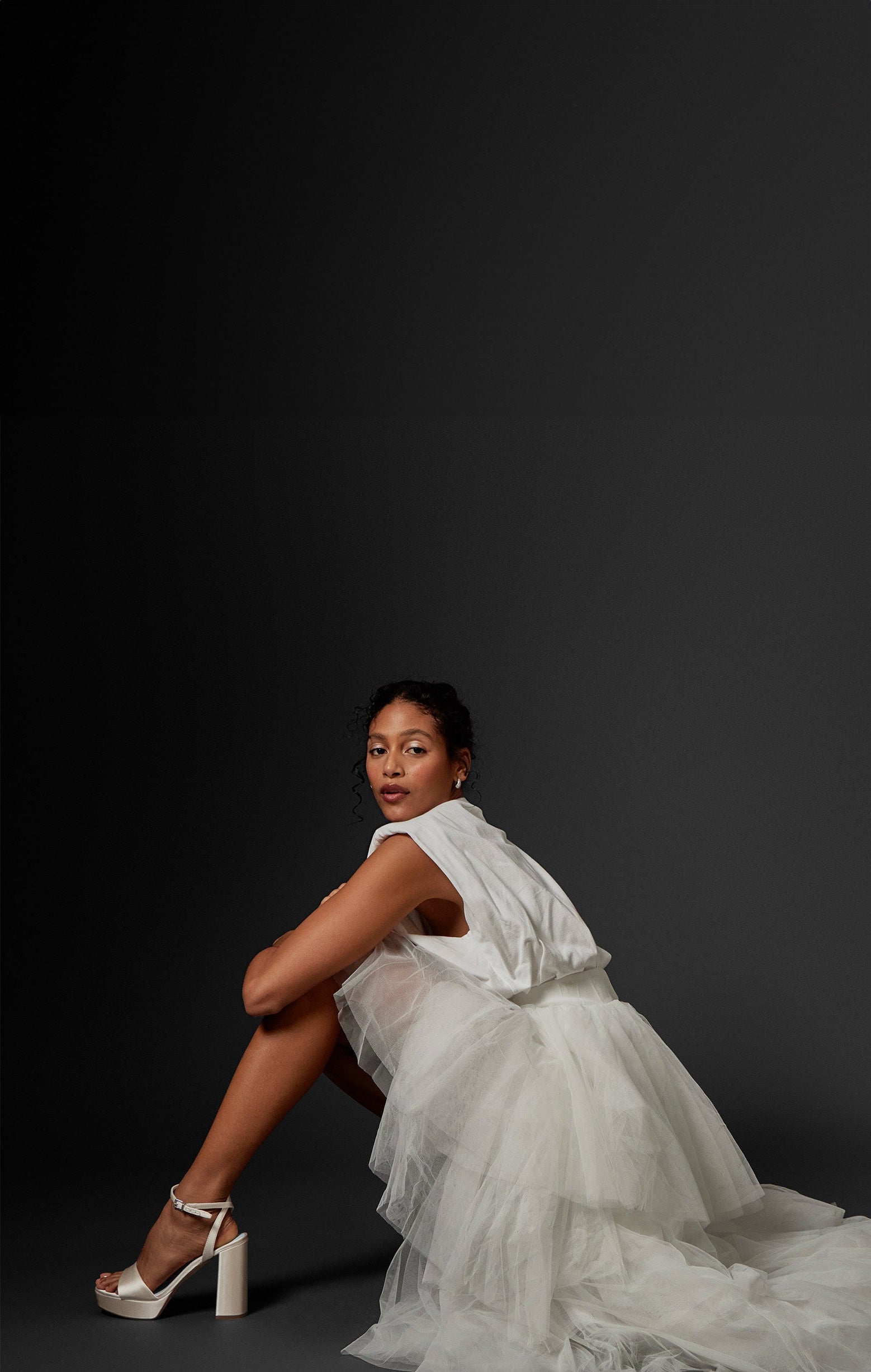 Women sitting in a bridal gown wearing the Pendry Platform Sandal in Milk