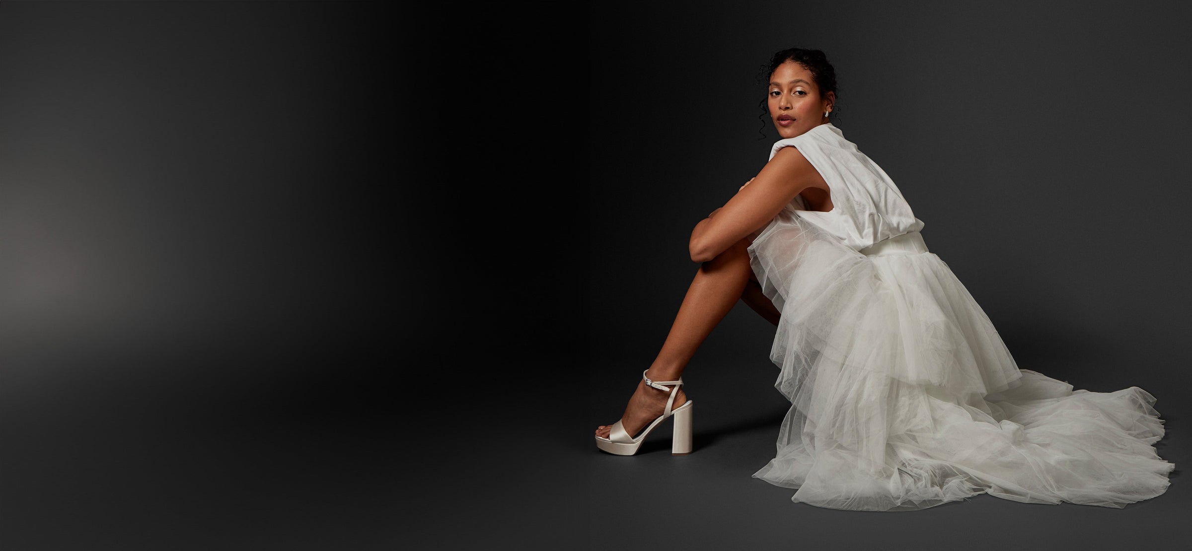 Women sitting in a bridal gown wearing the Pendry Platform Sandal in Milk