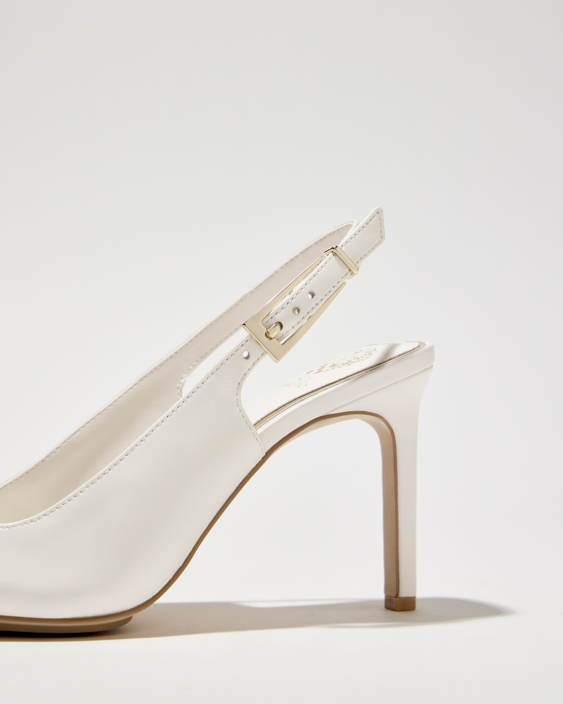 A close-up of the Vince Camuto Brendie Pump, a white pointed toe slingback with a gold buckle on the strap and a high heel, displayed against a plain light background.