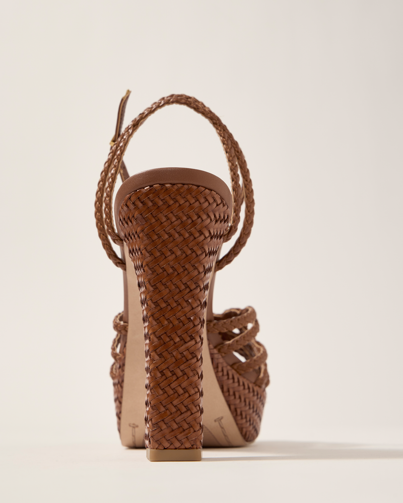 A close-up rear view of the Vince Camuto Samlee Strappy Platform Sandal showcases its brown woven texture and braided ankle strap against a plain, light background.