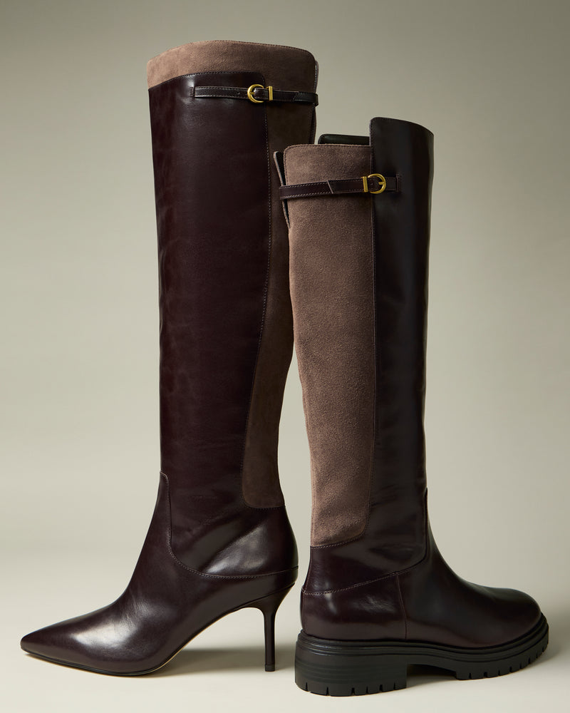 Two Vince Camuto “Bertla Extra Wide Calf” knee-high women’s boots: one features a high heel and pointed toe, while the other has a chunky tread sole. Both are crafted from dark brown leather with suede backs and finished with small gold buckles near the top.