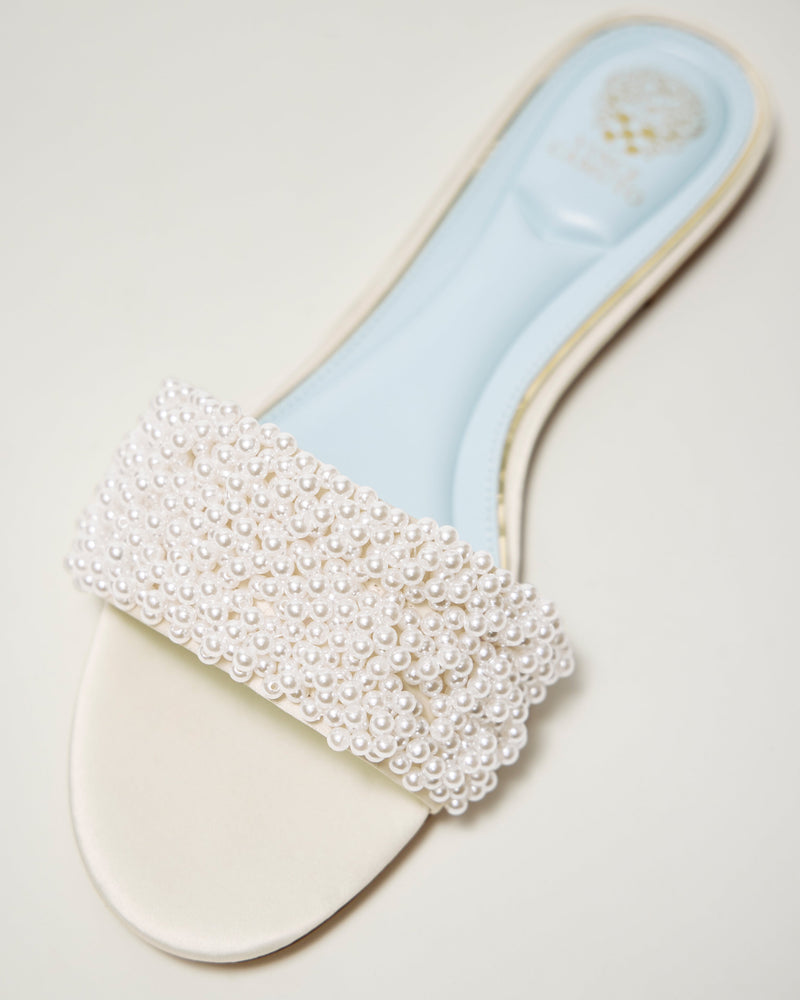 The Balea Beaded Sandal by Vince Camuto features a cream color, light blue insole, and a wide strap topped with clustered white pearls for stylish beaded detailing.