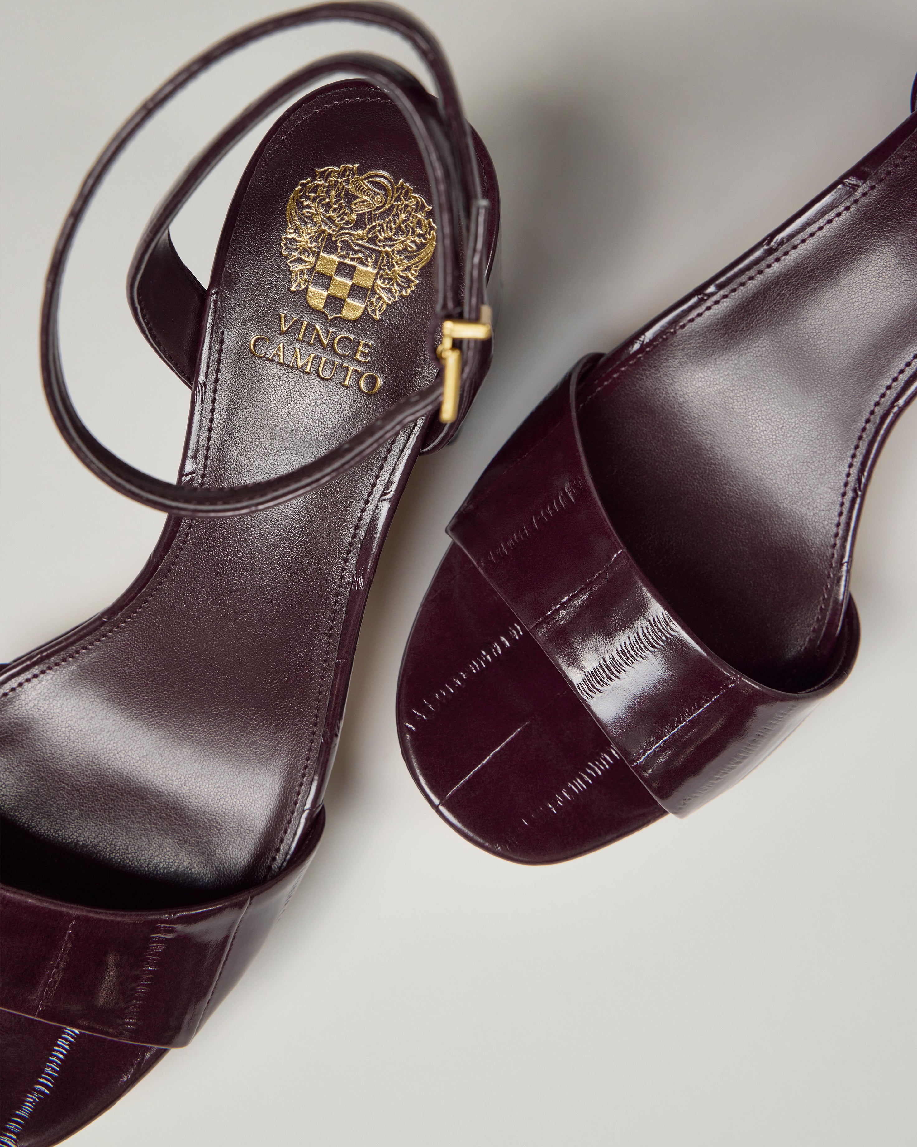 Close-up of dark burgundy Vince Camuto Pendreya Platform Sandals with ankle straps, block heels, and the brand logo visible on the insole, displayed on a light background.