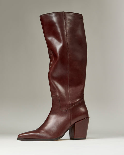 The Vince Camuto Pamlia Extra Wide Calf Knee High Boot is shown upright against a plain light gray background. It features tall brown leather, a rounded toe, chunky block heel, and subtle western-inspired styling.