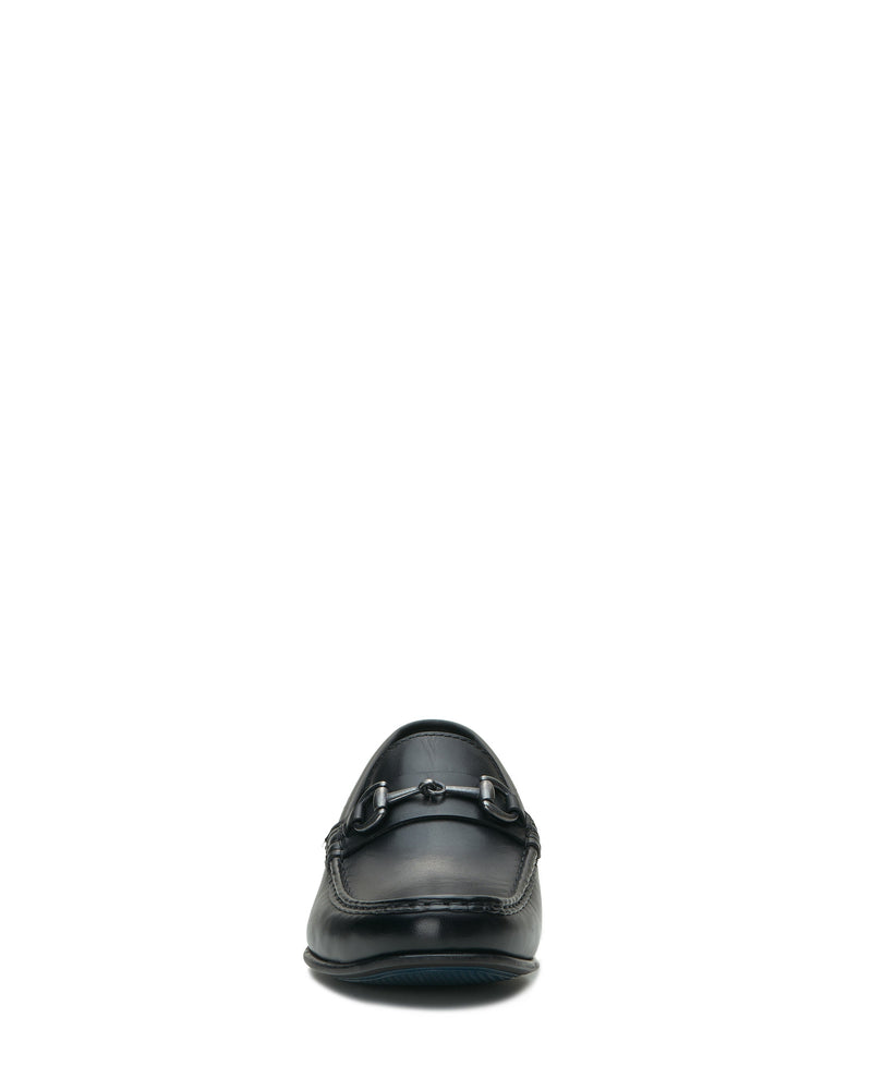 The Vince Camuto Men’s Caelan Loafer is displayed from the front against a plain white background, showcasing its black leather construction, moccasin toe design, and decorative horse-bit hardware across the upper.