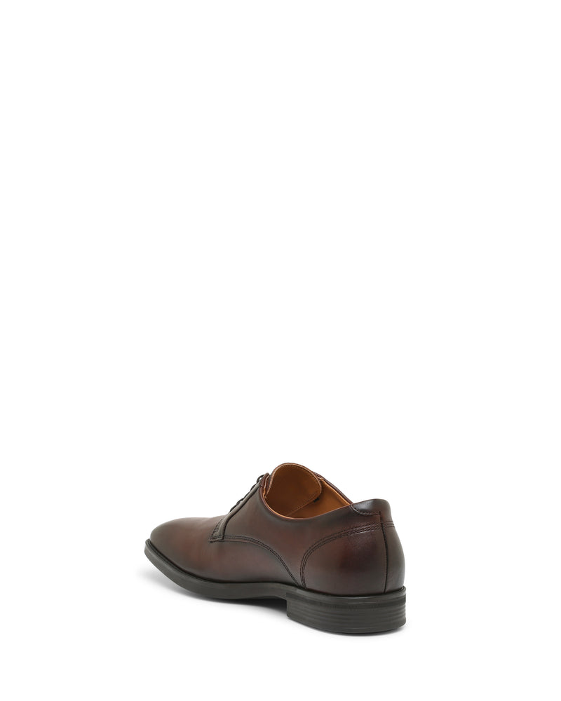 A single Vince Camuto Men’s Draymand Oxford dress shoe in brown leather, shown from the back-left angle with a black sole and minimal stitching detail, set against a plain white background.