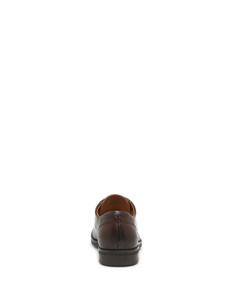 A single Vince Camuto Men’s Draymand Oxford in brown leather is shown from the back on a white background, featuring a black sole and visible stitching detail on the heel.