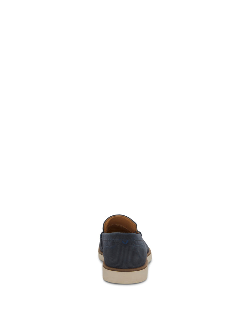 The Vince Camuto Men's Sevrin Casual Loafer is shown from the back in navy blue with a tan interior, white sole, and comfy EVA insole, set against a plain white background.