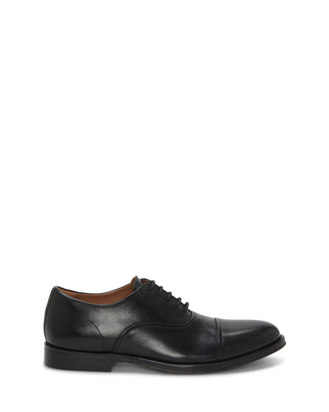 The Vince Camuto Men's Urii Dress Oxford is a formal black leather shoe featuring a sleek cap toe, black laces, and a low heel, shown on a white background.