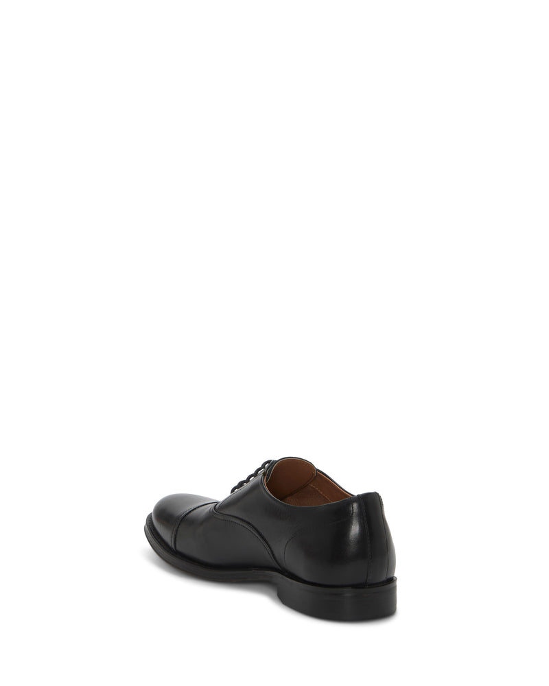 A single Vince Camuto Men's Urii Dress Oxford, black leather cap toe with laces, is shown from the back and slightly to the side against a plain white background.