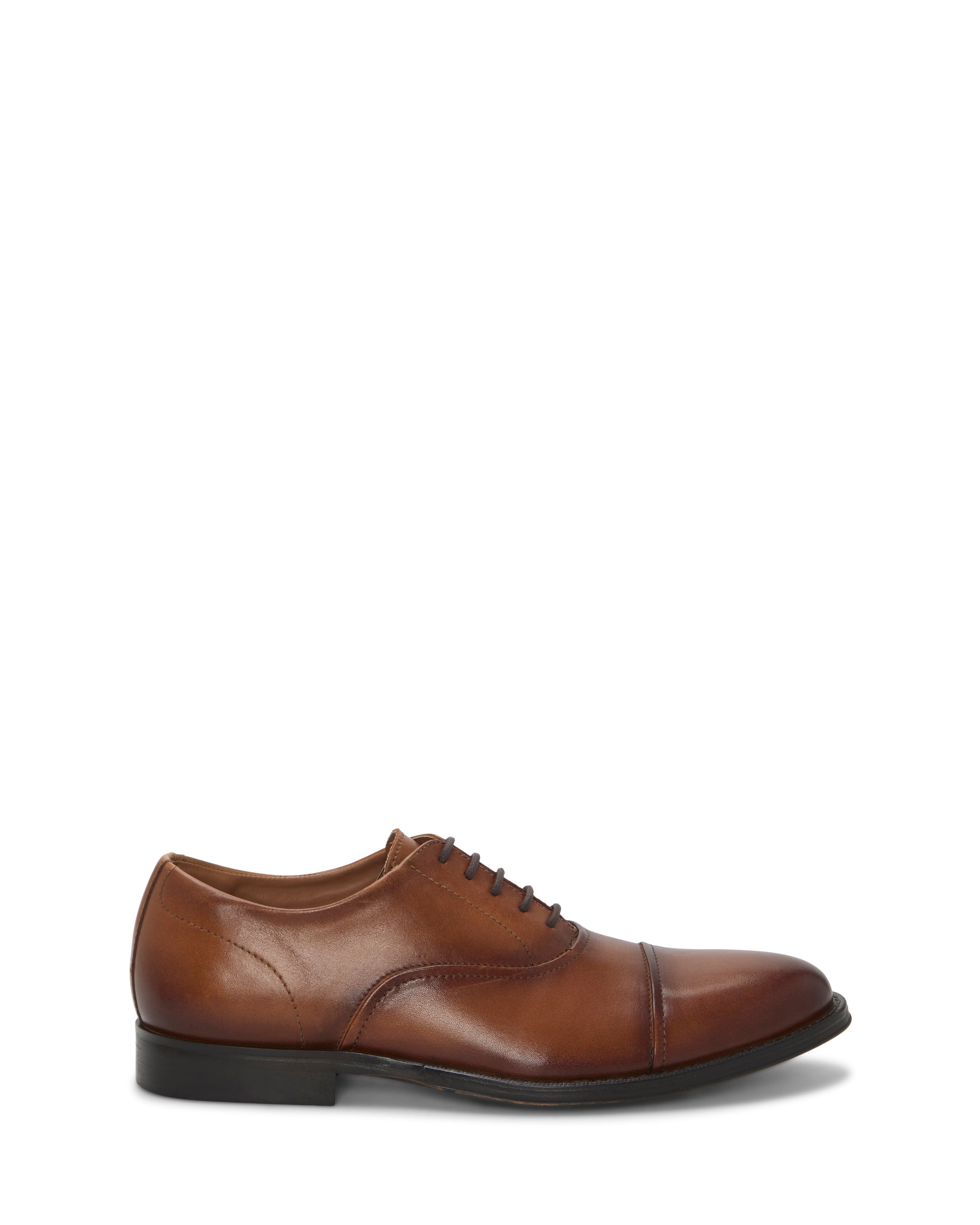 The Vince Camuto Men's Urii Dress Oxford, a brown leather shoe with a cap toe, lace-up design, and black sole, is shown in profile against a white background.