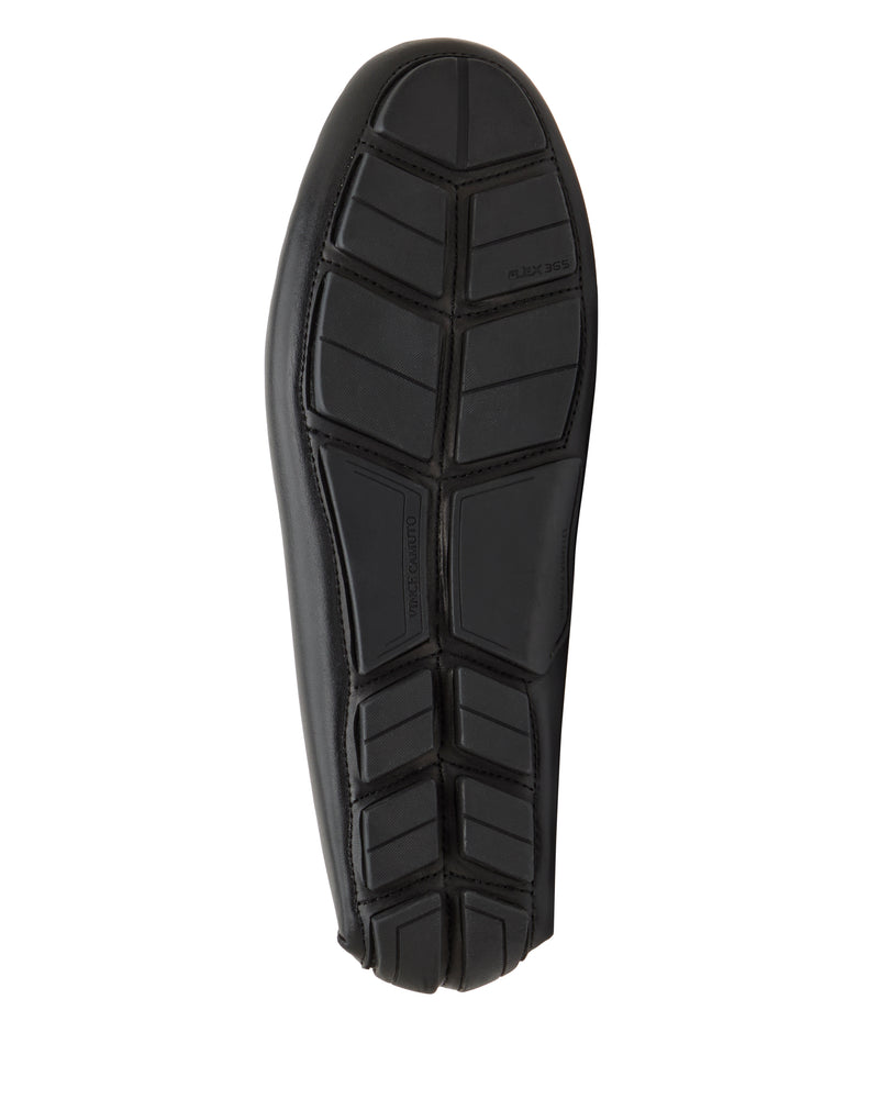 The black rubber sole of the Vince Camuto Men's Vitzroy Slip-On showcases geometric tread and segmented grooves for flexibility and grip, photographed from below against a white background.