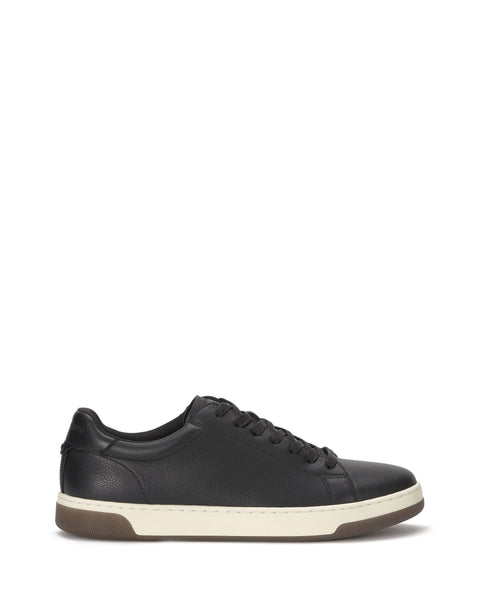 The Vince Camuto Men's Wynsten Sneaker is a black low-top with white sole and black laces, shown in side profile on a white background. It features an EVA insole for comfort, making it ideal as an everyday casual sneaker.