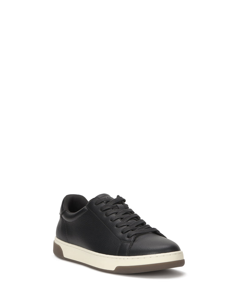 The Vince Camuto Men's Wynsten Sneaker in black, featuring black laces, a white midsole, brown outsole, and EVA insole, is shown at a slight left-facing angle against a white background.