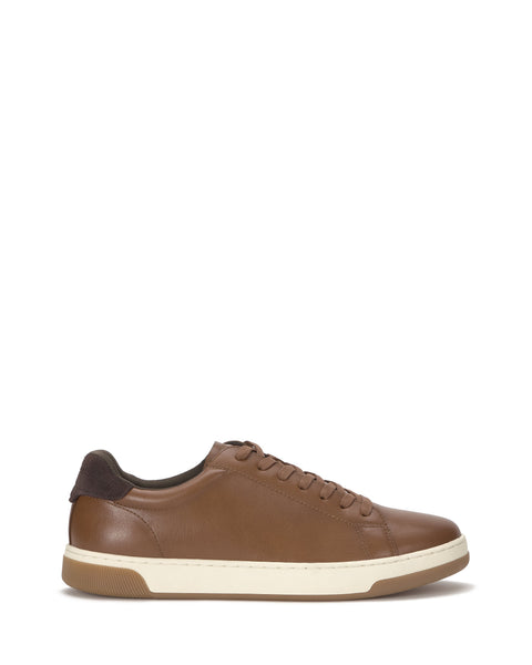 The Men's Wynsten Sneaker by Vince Camuto features brown leather, matching laces, a white midsole, brown rubber outsole, EVA insole cushioning, a dark brown heel accent, and a minimalist low-top design for casual style.