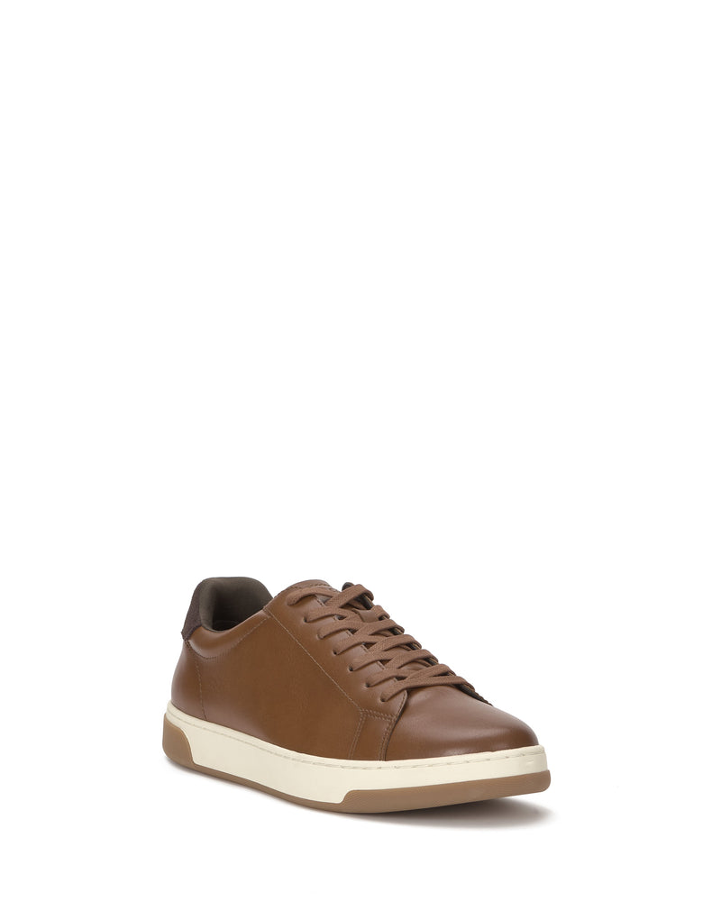 The Vince Camuto Men's Wynsten Sneaker features a brown low-top design with brown laces and a white sole, shown angled on a plain white background to highlight its stylish front and side, perfect for casual wear.