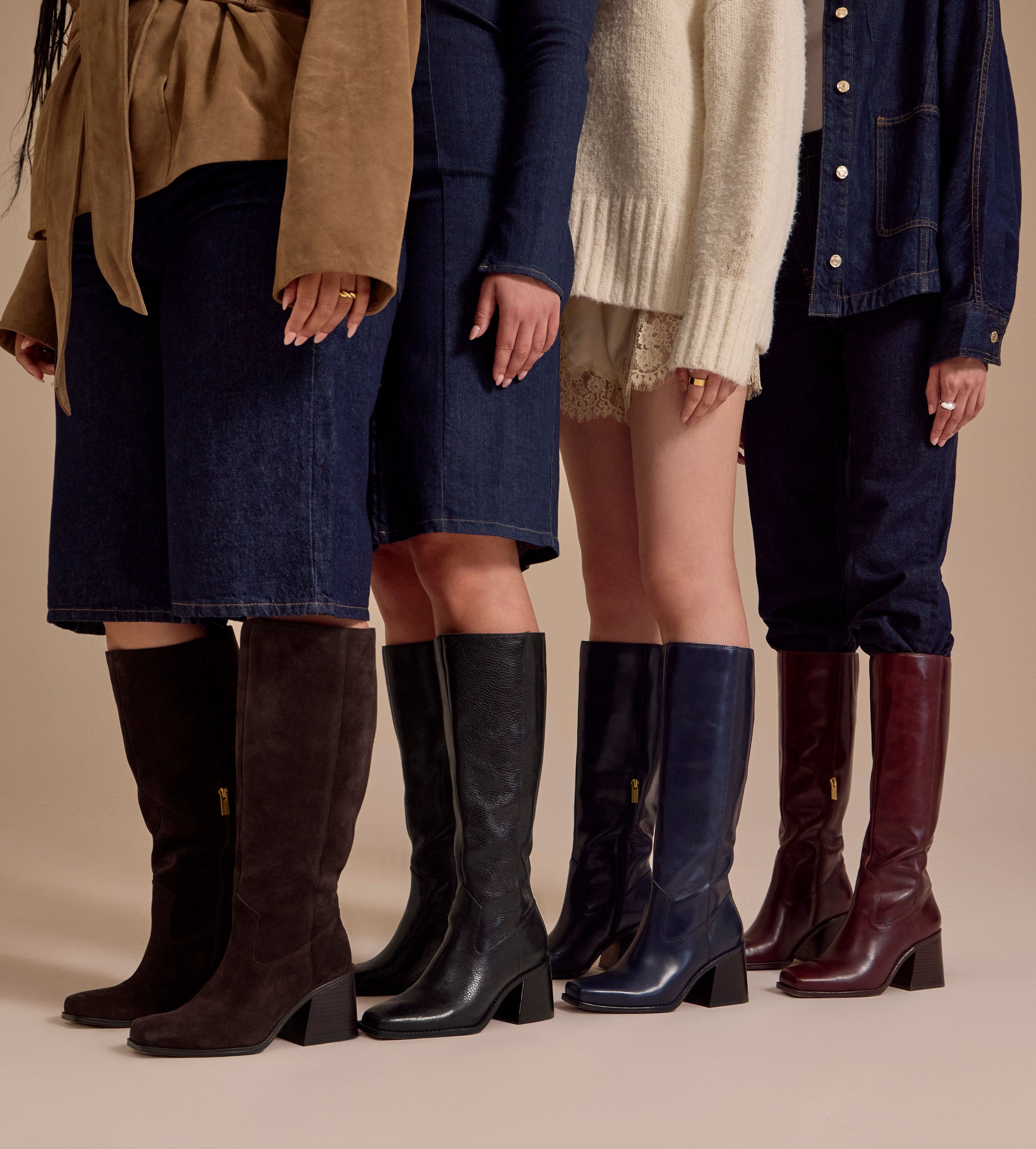 Four models shown from the waist down wearing knee-high boots in brown, black, navy, and burgundy, styled with different outerwear and jeans against a solid beige studio background.