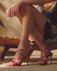 woman modeling bags and shoes on tan background